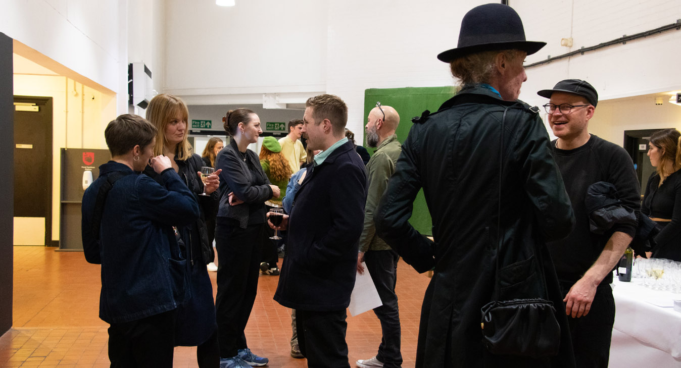 A group of people outside the gallery chatting