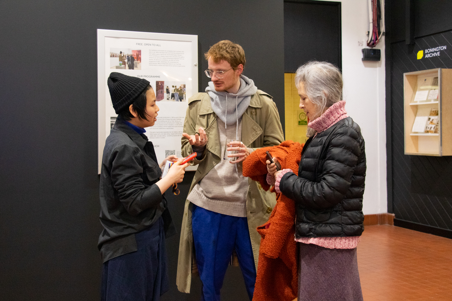 Three people at an exhibition launch.