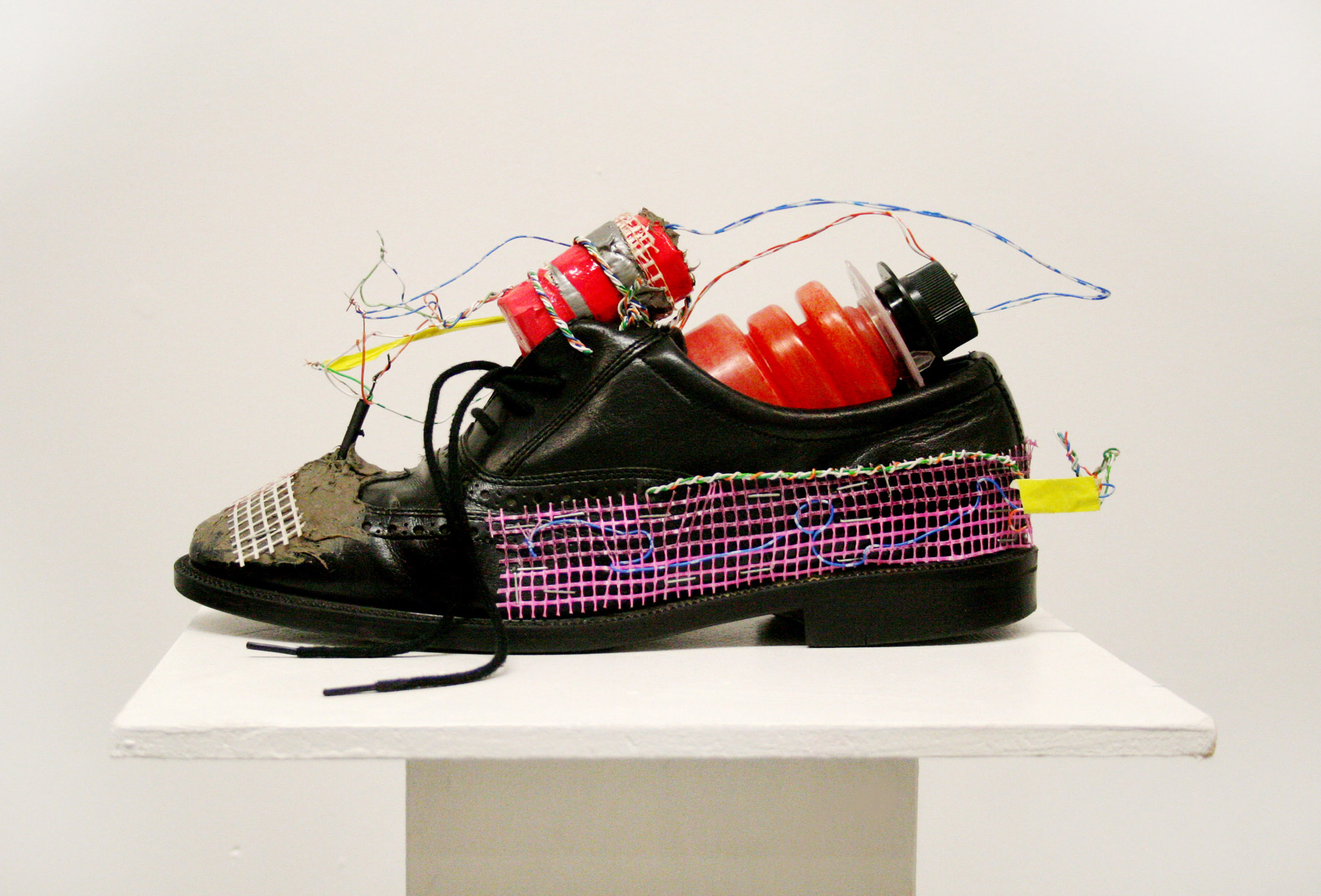 A black rouge show, with colourful pink and purple netting on the side, On the front, wires are held on with clay. Inside the show there is a red plastic container where the wires are hooked up from the front