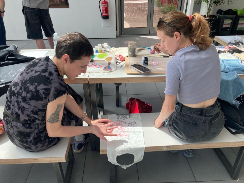 Two people taking part in a garment making and customisation workshop