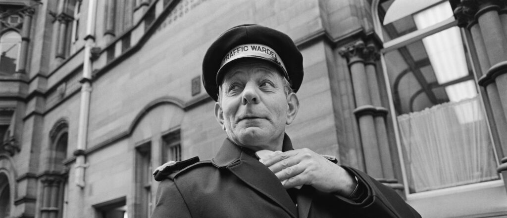 A black and white image of a traffic warden.